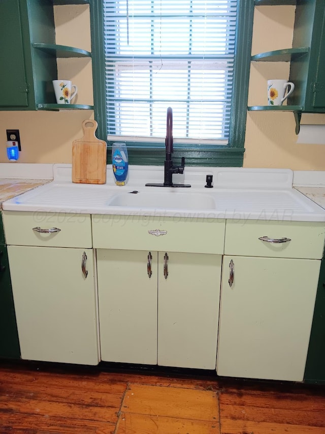 kitchen with light countertops, wood finished floors, and open shelves