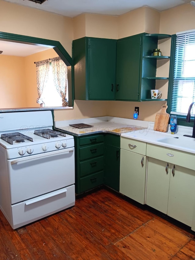 kitchen with dark wood-style floors, white gas range, a sink, and green cabinetry