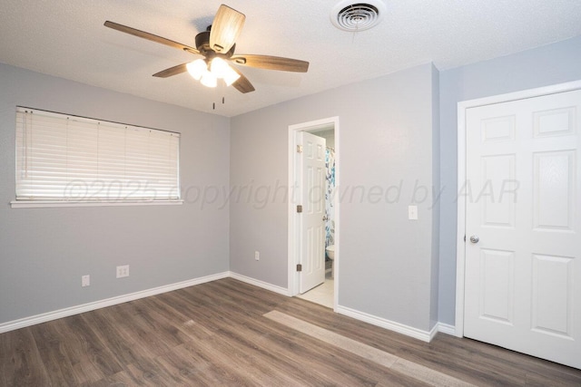 1301 Clyde St, Amarillo, TX 79106 - unfurnished bedroom with wood finished floors, connected bathroom, and a ceiling fan