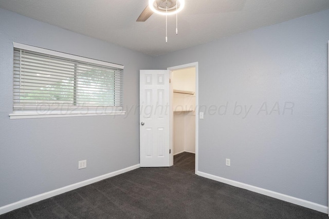 1301 Clyde St, Amarillo, TX 79106 - unfurnished bedroom featuring a spacious closet, dark carpet, a closet, and ceiling fan