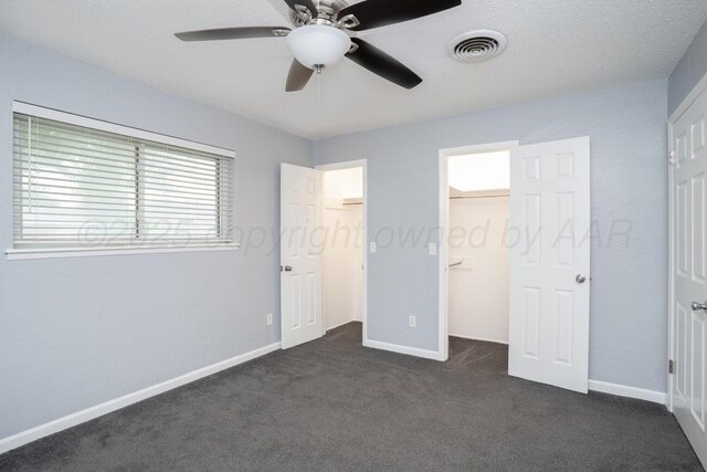 1301 Clyde St, Amarillo, TX 79106 - unfurnished bedroom with a spacious closet, dark colored carpet, a closet, and a ceiling fan