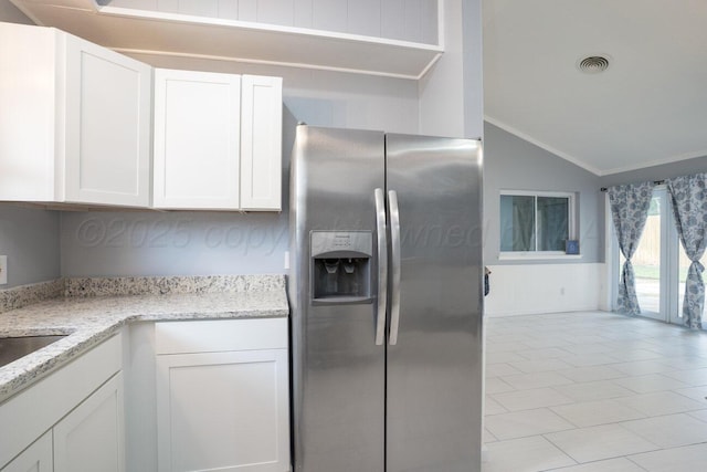 1301 Clyde St, Amarillo, TX 79106 - kitchen with stainless steel refrigerator with ice dispenser, vaulted ceiling, crown molding, white cabinets, and light stone countertops