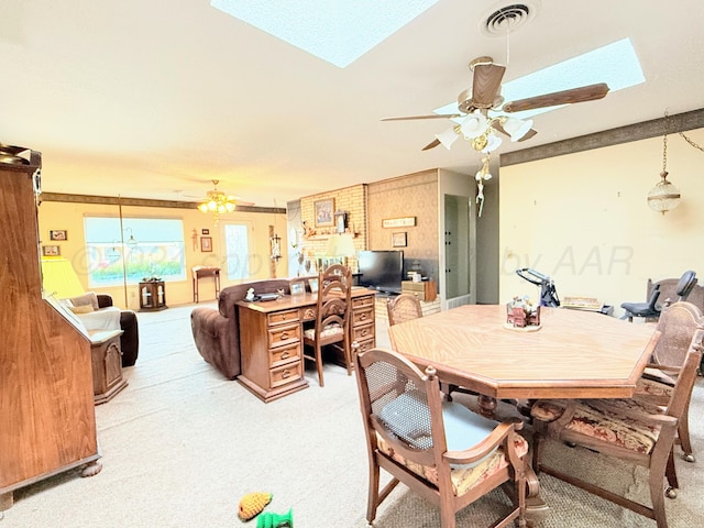 carpeted dining area with a skylight and ceiling fan