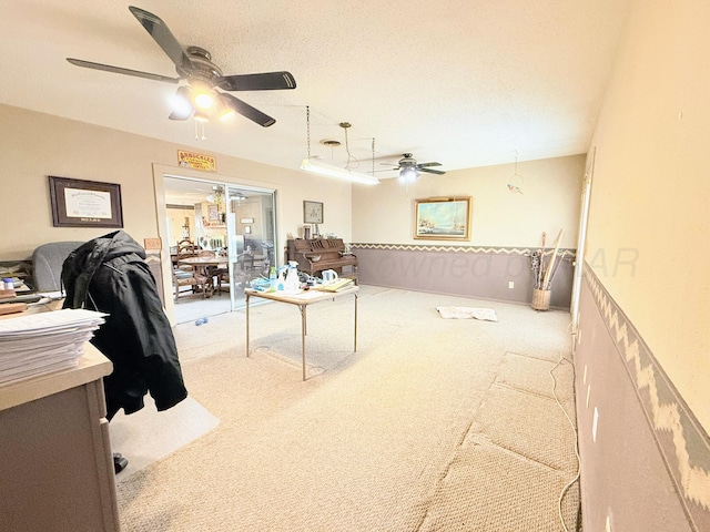 office space with a textured ceiling, light colored carpet, and ceiling fan