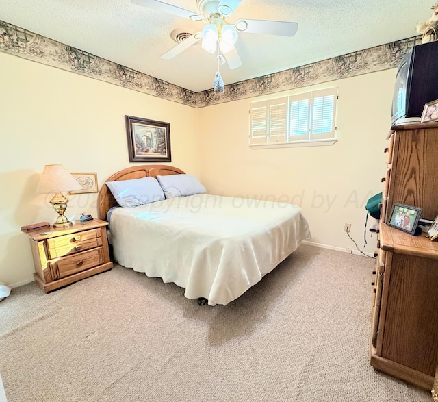 carpeted bedroom featuring a textured ceiling and ceiling fan