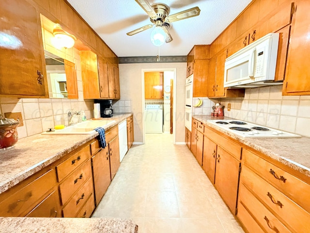 kitchen with decorative backsplash, sink, white appliances, and a textured ceiling