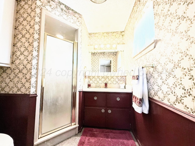 bathroom with vanity and a shower with shower door