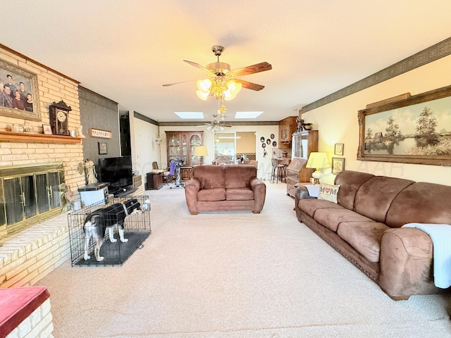 living room featuring a brick fireplace, ceiling fan, carpet, and a skylight