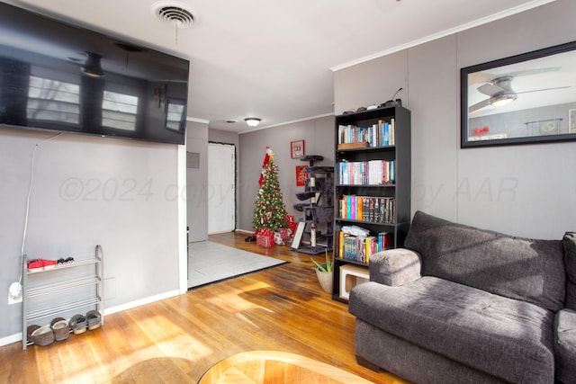 living area with wood-type flooring and ceiling fan