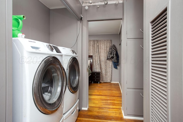 laundry room with wood-type flooring and independent washer and dryer