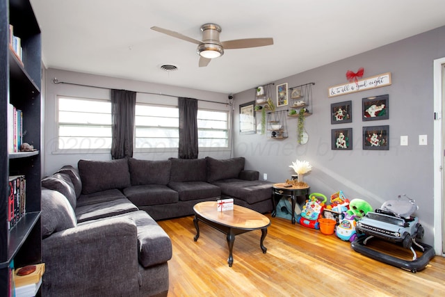 living room featuring hardwood / wood-style floors and ceiling fan