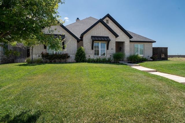 5504 Wesley Dr, Amarillo, TX 79119 - french country home with brick siding, a front lawn, a chimney, and roof with shingles