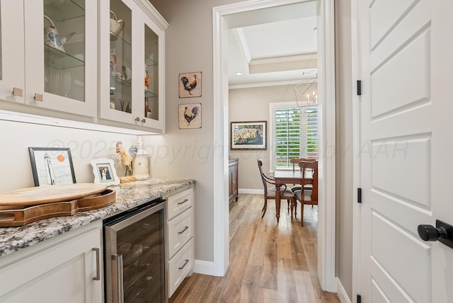 5504 Wesley Dr, Amarillo, TX 79119 - indoor dry bar featuring beverage cooler, crown molding, light wood-type flooring, a tray ceiling, and a chandelier