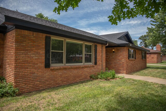 301 Maple Ave, Panhandle, TX 79068 - view of side of home featuring brick siding, a lawn, and a shingled roof