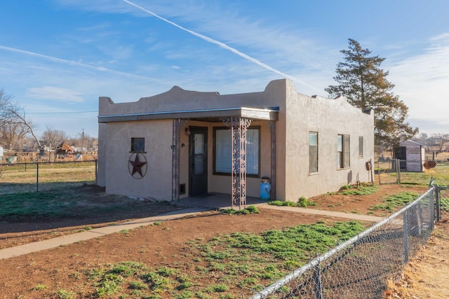 southwest-style home featuring fence and stucco siding