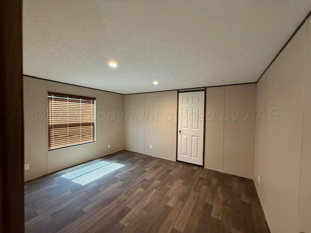 spare room with dark wood-type flooring and recessed lighting