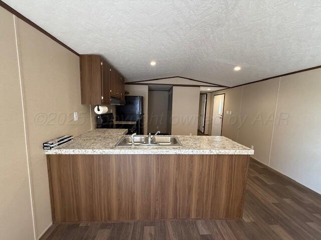 kitchen with dark wood-style flooring, a textured ceiling, a peninsula, black electric range oven, and a sink