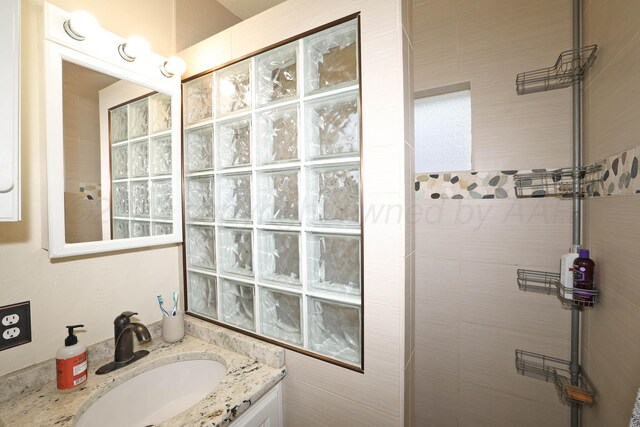 full bath featuring walk in shower and vanity