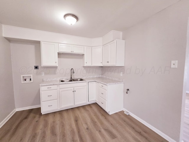 4301 S Washington St, Amarillo, TX 79110 - kitchen with light wood-type flooring, light countertops, and white cabinetry
