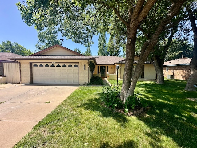6210 Camden Ln, Amarillo, TX 79109 - ranch-style house with an attached garage, driveway, brick siding, and a front yard