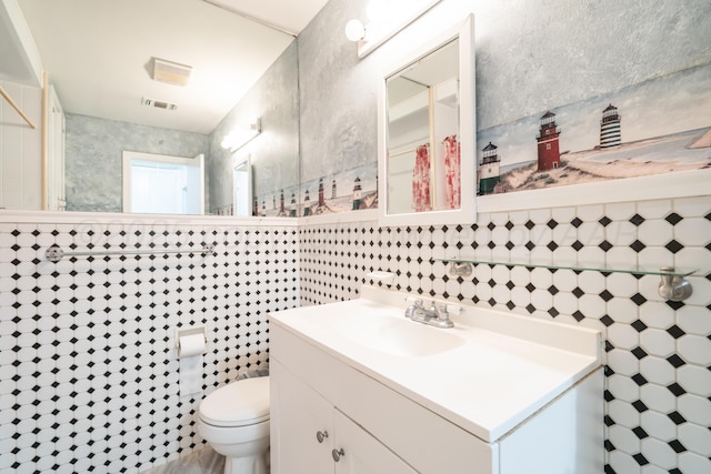 3519 S Julian Blvd, Amarillo, TX 79102 - bathroom with toilet, visible vents, tile walls, and vanity