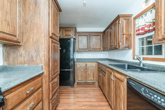 3519 S Julian Blvd, Amarillo, TX 79102 - kitchen featuring brown cabinetry, a sink, light wood-style flooring, and black appliances