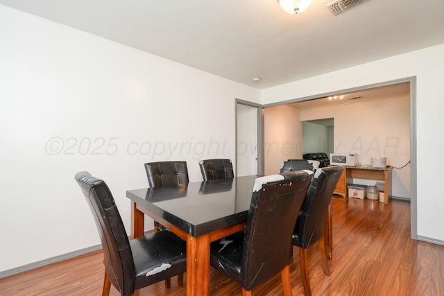 3519 S Julian Blvd, Amarillo, TX 79102 - dining room with baseboards, wood finished floors, and visible vents