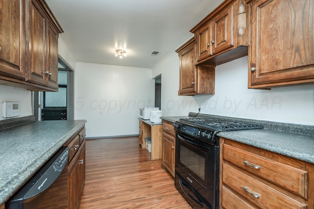 3519 S Julian Blvd, Amarillo, TX 79102 - kitchen with visible vents, dark countertops, black appliances, light wood finished floors, and ornamental molding