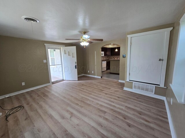 1313 Skyline Dr, Amarillo, TX 79108 - unfurnished living room featuring arched walkways, ceiling fan, and light wood finished floors