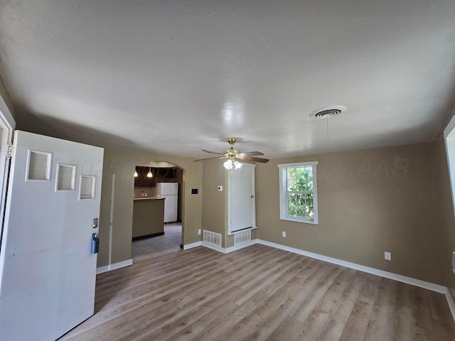 1313 Skyline Dr, Amarillo, TX 79108 - unfurnished living room featuring light wood-style floors, arched walkways, and a ceiling fan