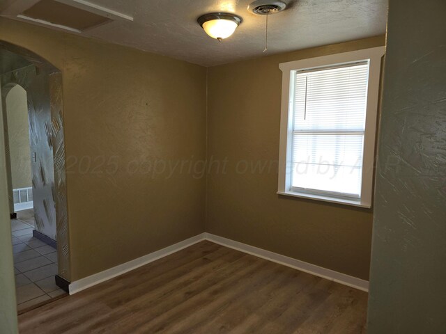 1313 Skyline Dr, Amarillo, TX 79108 - unfurnished room with attic access, wood finished floors, baseboards, and arched walkways
