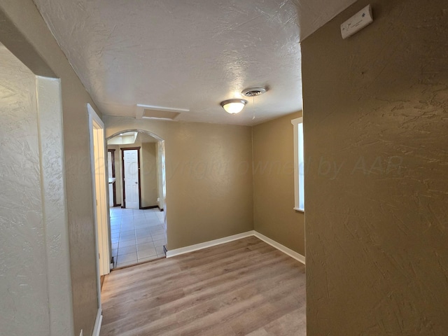 1313 Skyline Dr, Amarillo, TX 79108 - spare room with wood finished floors, a textured ceiling, a textured wall, and arched walkways