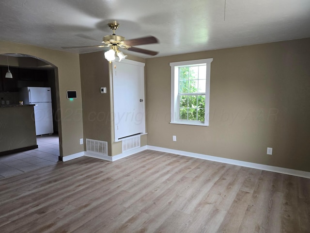 1313 Skyline Dr, Amarillo, TX 79108 - spare room with arched walkways, light wood-type flooring, a ceiling fan, and baseboards