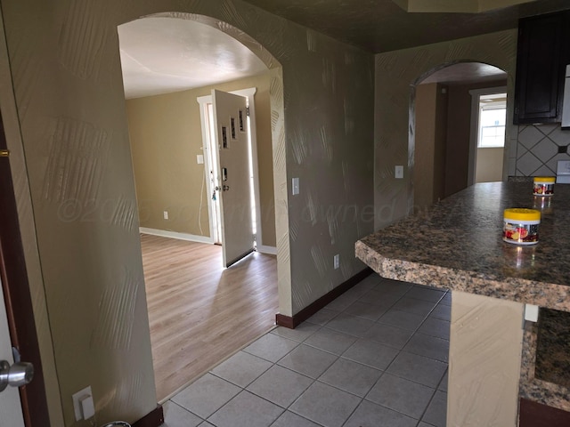 1313 Skyline Dr, Amarillo, TX 79108 - kitchen featuring arched walkways, light tile patterned floors, and baseboards