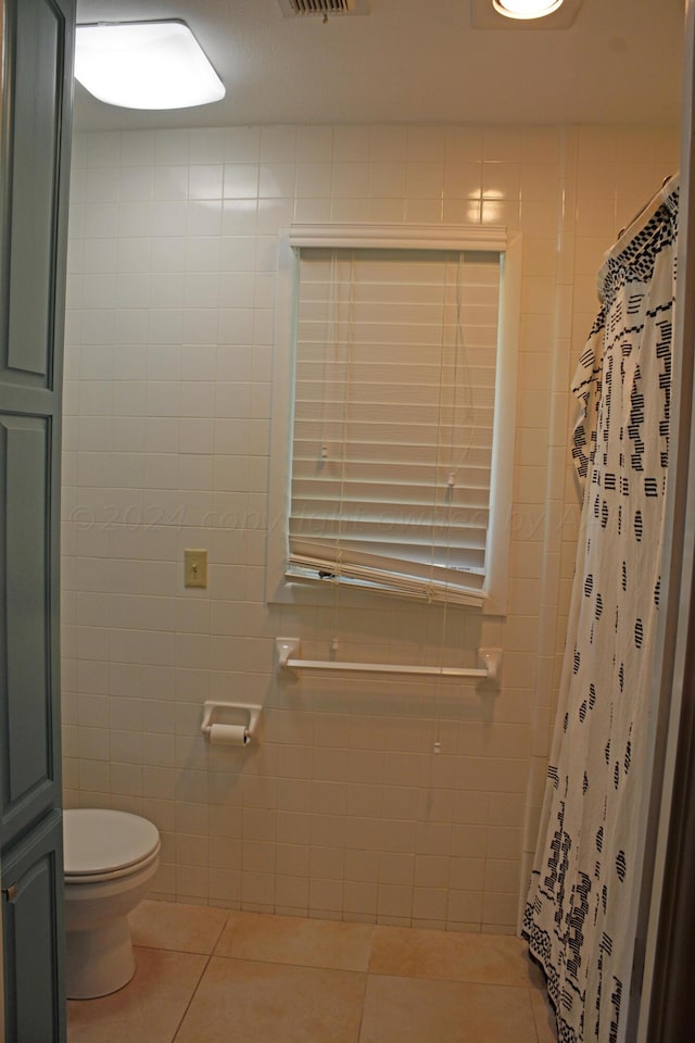 bathroom with walk in shower, tile patterned flooring, and tile walls