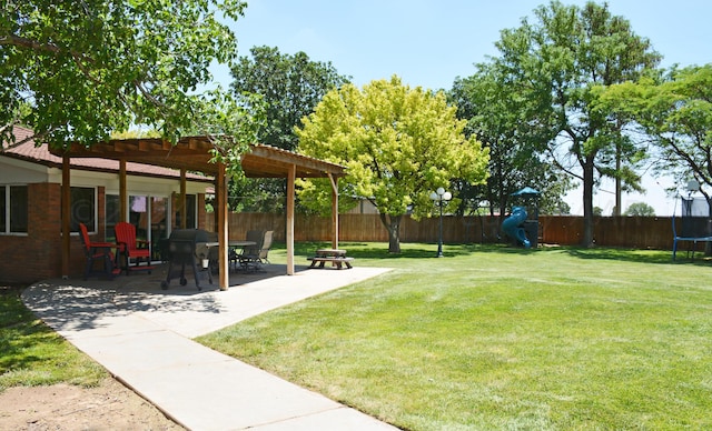 view of yard with a patio area, a pergola, and a trampoline