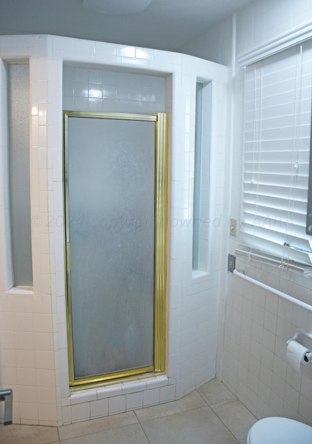 bathroom featuring walk in shower, tile patterned floors, and tile walls