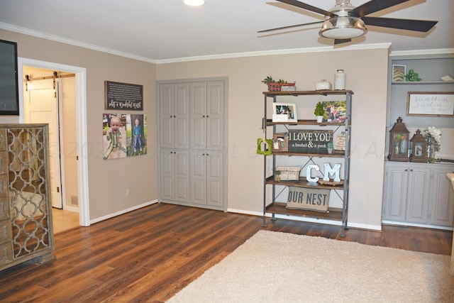 interior space featuring dark wood-type flooring, a barn door, ceiling fan, and crown molding