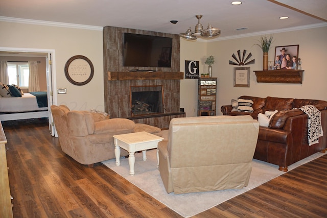 living room with ornamental molding, a fireplace, and dark wood-type flooring