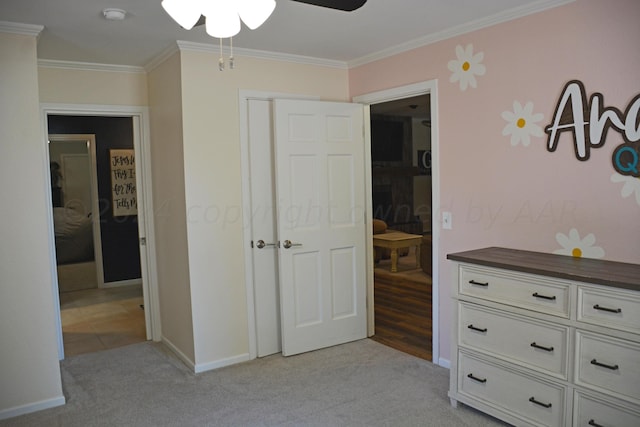 carpeted bedroom with ornamental molding and ceiling fan