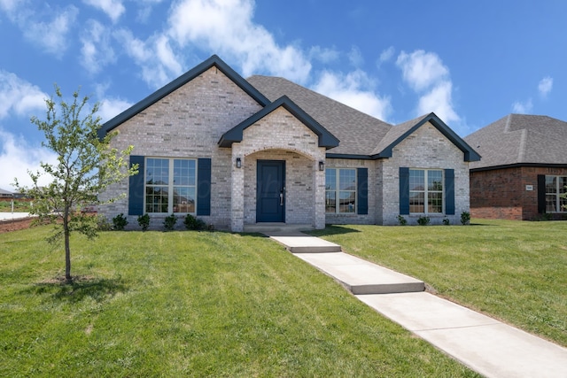 7602 Castleman Rd, Amarillo, TX 79119 - view of front of home featuring brick siding, a front yard, and a shingled roof