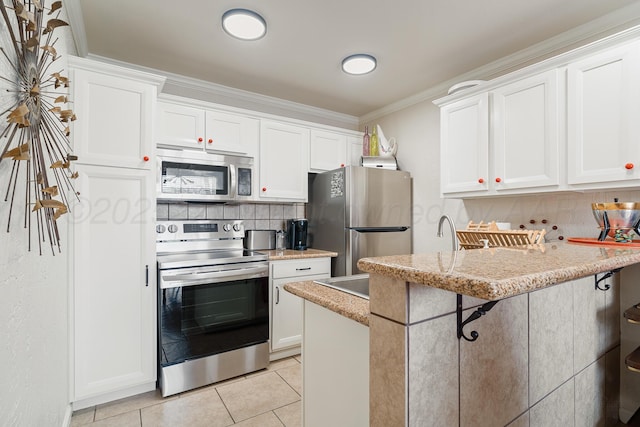 kitchen with appliances with stainless steel finishes, light tile patterned flooring, white cabinetry, and tasteful backsplash