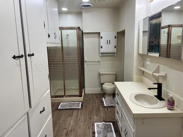 bathroom with walk in shower, toilet, vanity, and hardwood / wood-style flooring