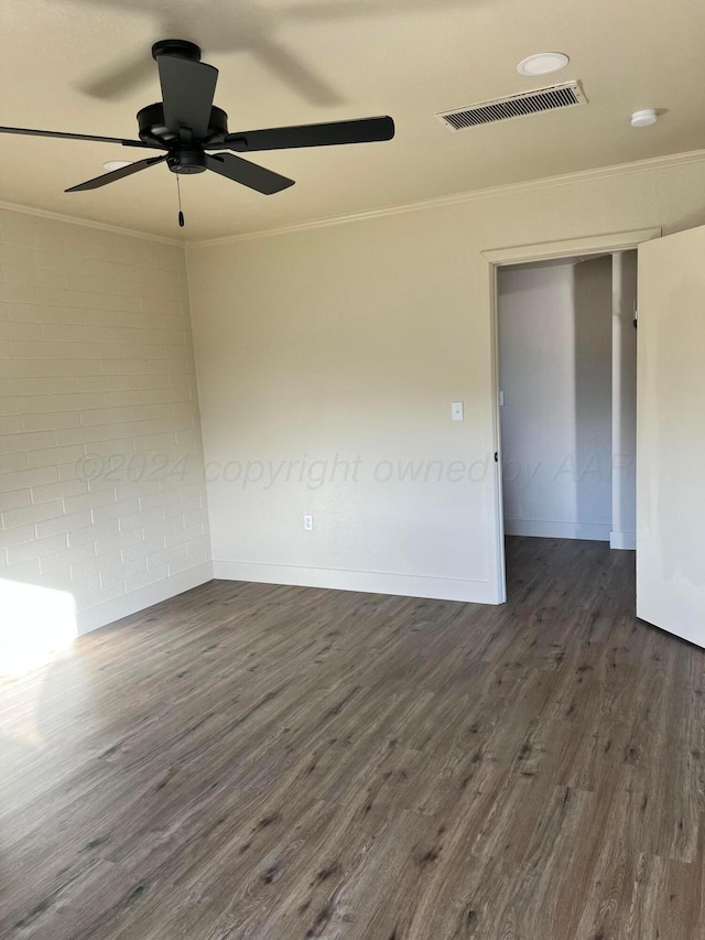 empty room featuring ornamental molding, ceiling fan, and dark wood-type flooring