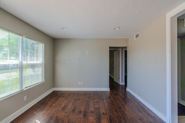 unfurnished room with dark wood-style floors, baseboards, and recessed lighting