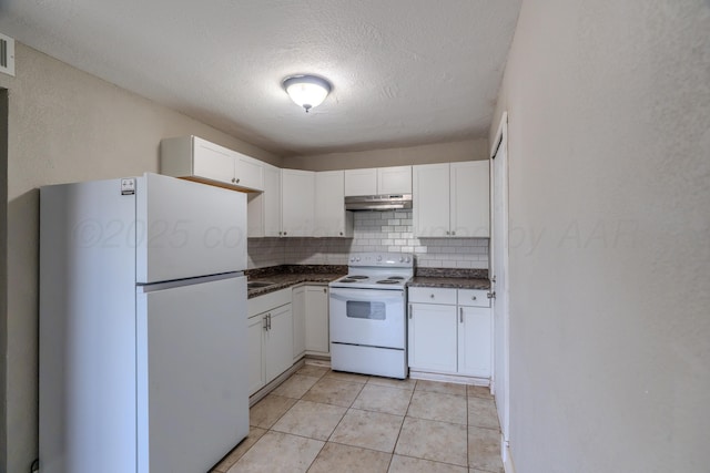 kitchen with white appliances, under cabinet range hood, dark countertops, backsplash, and white cabinetry