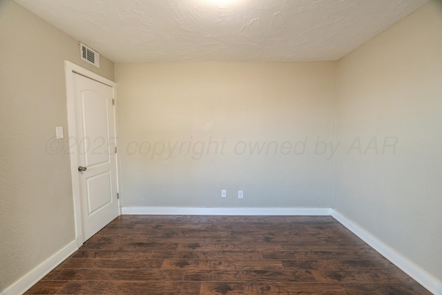 unfurnished room with dark wood-style flooring and baseboards