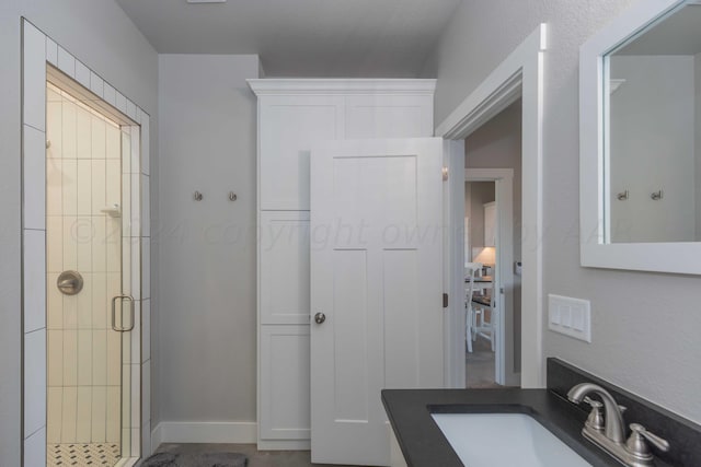 bathroom with vanity and a shower with door