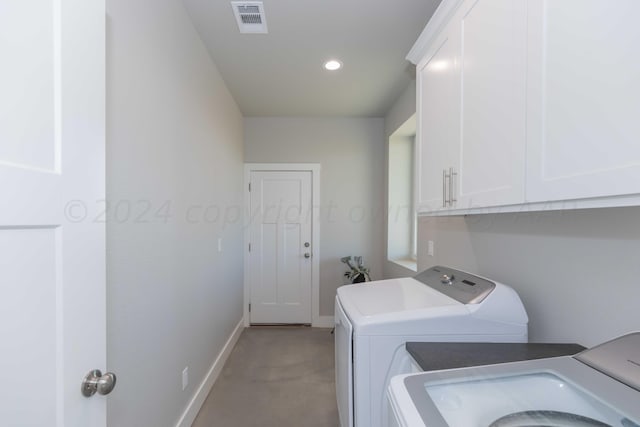 clothes washing area featuring cabinets and independent washer and dryer