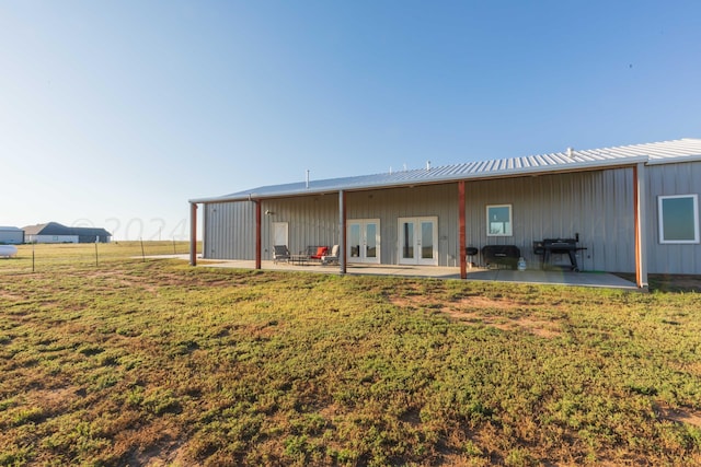 rear view of property with a yard, french doors, and a patio area